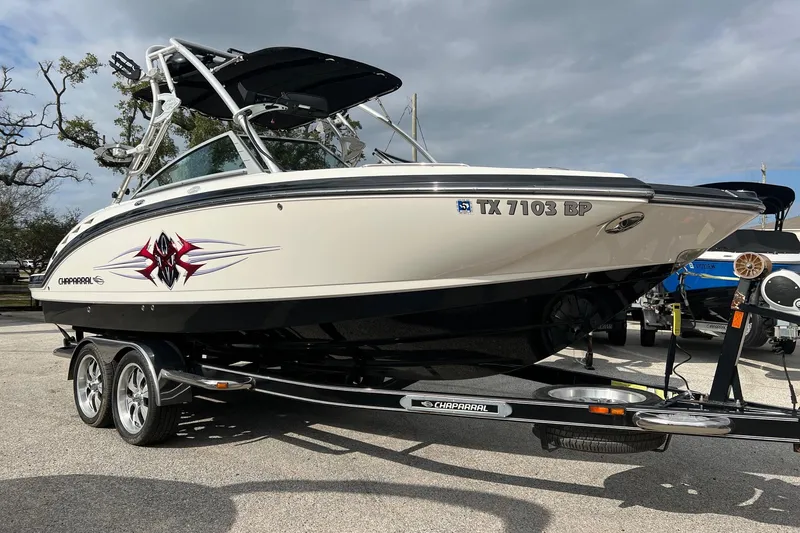 The Image of 2011 Chaparral Sunesta 244 Xtreme boat on trailer, side view with custom graphics. - 0