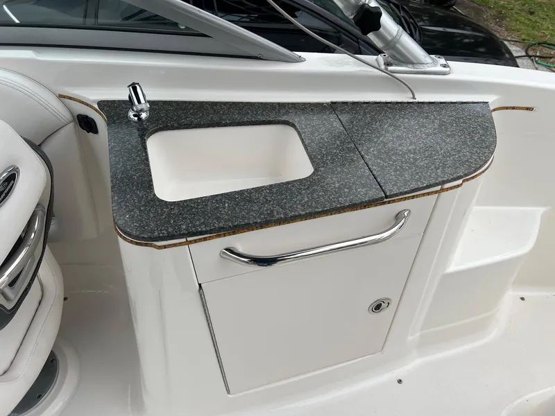 Slide: The Image of 2011 Chaparral Sunesta 244 Xtreme boat sink with granite countertop and storage cabinet. - 18
