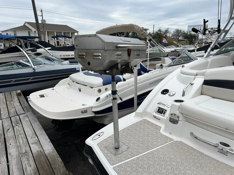 Slide: The Image of 2011 Chaparral Sunesta 244 Xtreme boat docked, featuring spacious seating and sleek design. - 2