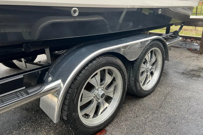 Slide: The Image of 2011 Chaparral Sunesta 244 Xtreme boat trailer with dual wheels on wet pavement. - 21