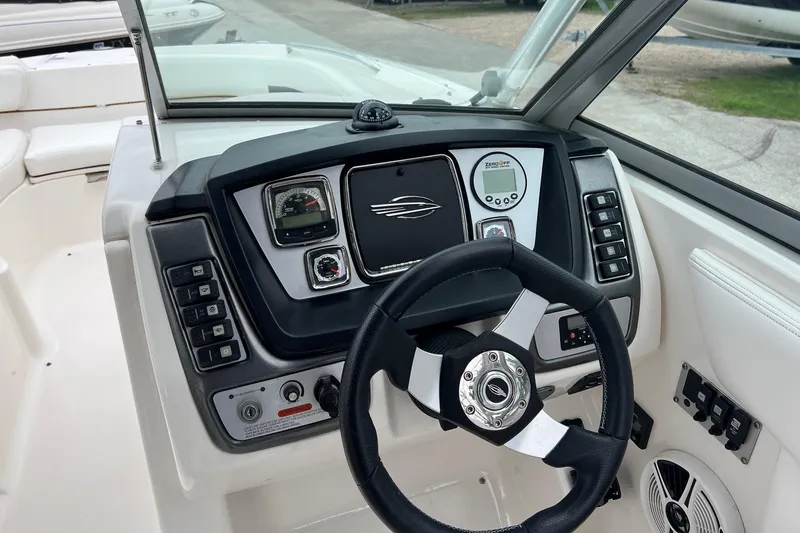 Slide: The Image of 2011 Chaparral Sunesta 244 Xtreme boat dashboard with steering wheel and controls. - 9