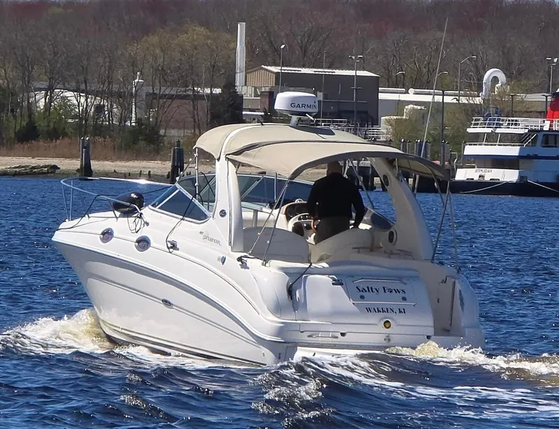 Slide: The Image of 2002 Sea Ray Sundancer boat cruising on a river near a marina. - 3