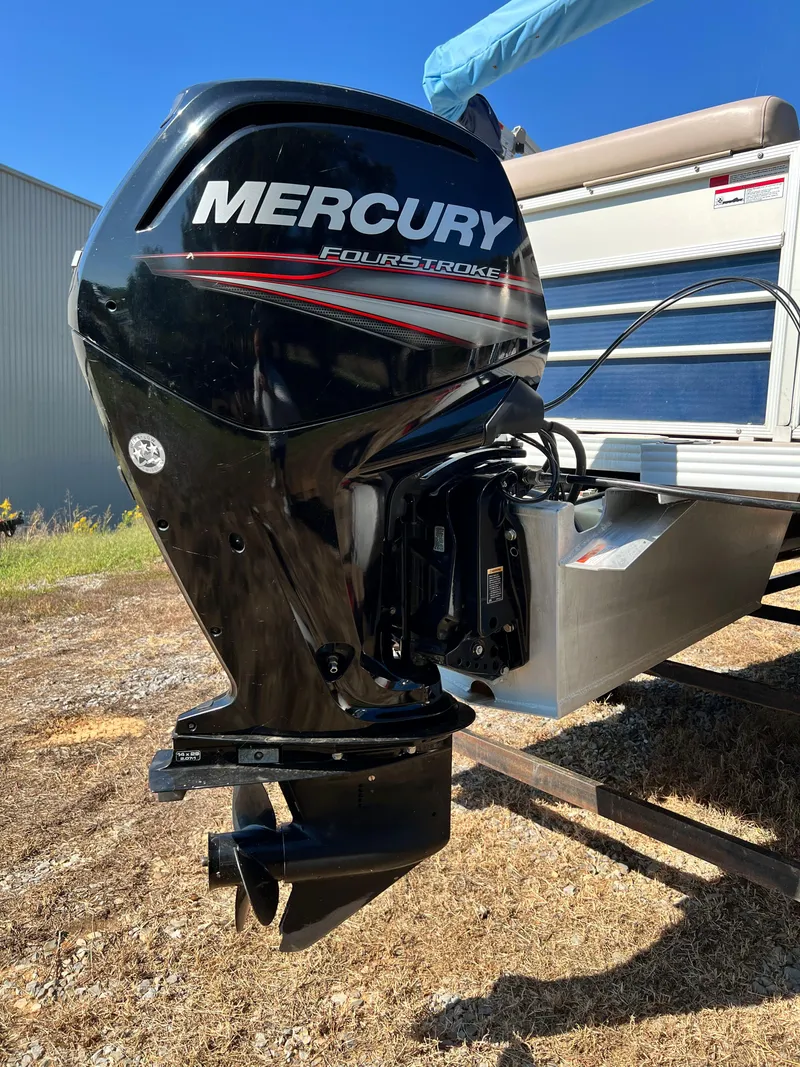 Slide: The Image of 2014 Crest 210FC boat with Mercury FourStroke outboard motor, parked on dry grass. - 8