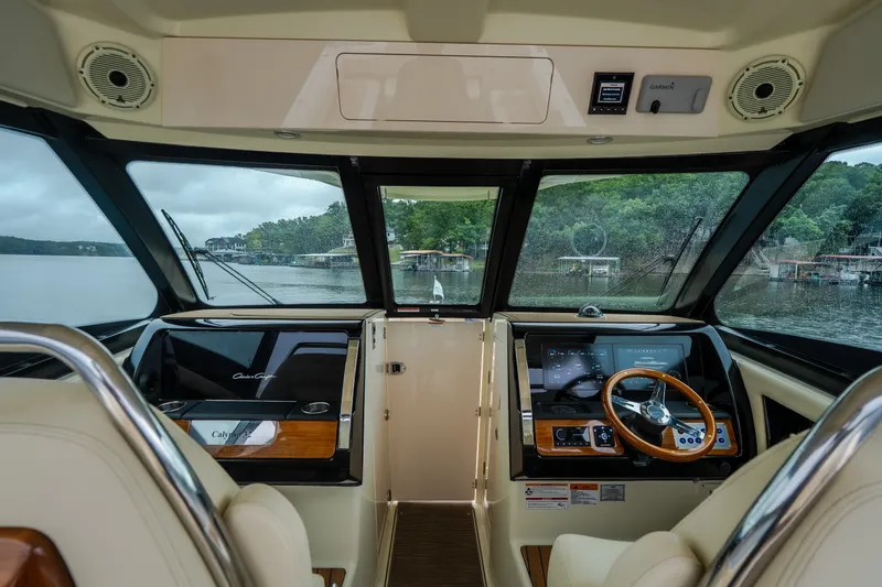 Slide: The Image of 2024 Chris-Craft Calypso 32 helm with modern controls and scenic lake view. - 31