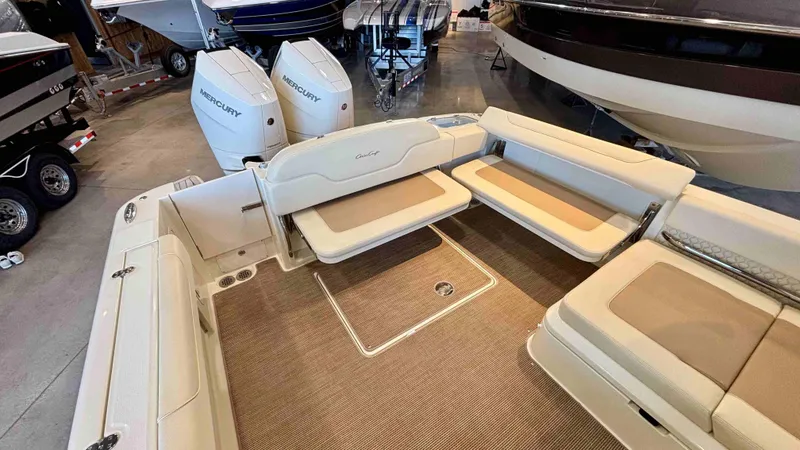 Slide: The Image of 2024 Chris-Craft Calypso 32 CT boat interior with beige seating and Mercury engines. - 10