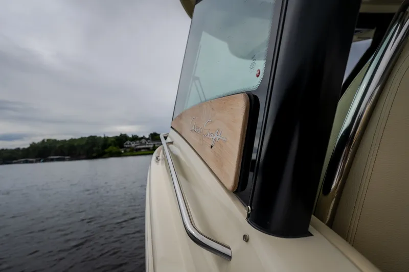 Slide: The Image of 2024 Chris-Craft Calypso 32 boat detail with logo, on a serene lake background. - 67
