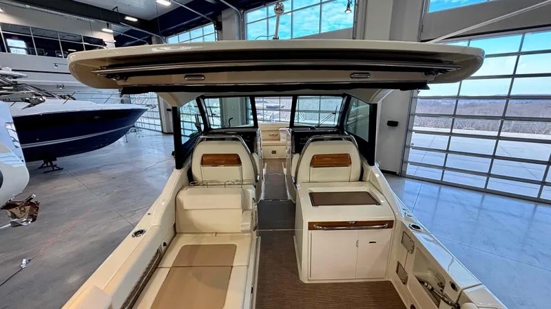 Slide: The Image of 2024 Chris-Craft Calypso 32 CT interior with luxurious seating and modern design in a showroom. - 14