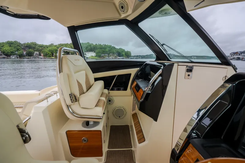 Slide: The Image of 2024 Chris-Craft Calypso 32 cockpit with luxurious seating and modern dashboard, overlooking serene waters. - 44