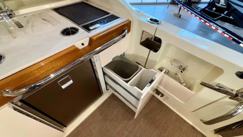 Slide: The Image of 2024 Chris-Craft Calypso 32 CT interior with kitchenette and storage compartments. - 21