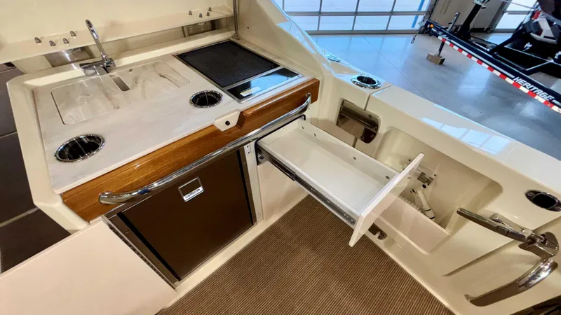 Slide: The Image of 2024 Chris-Craft Calypso 32 CT boat interior with kitchenette and storage features. - 22