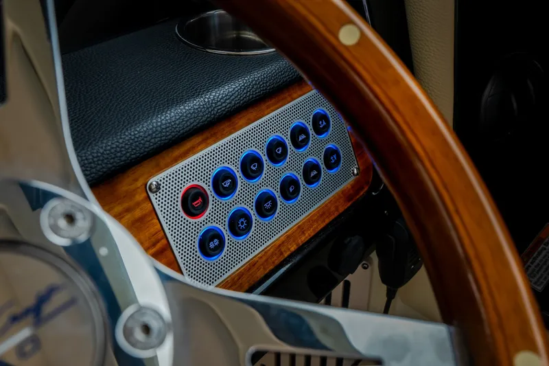 Slide: The Image of Dashboard controls of 2024 Chris-Craft Calypso 32 boat with wooden steering wheel. - 36