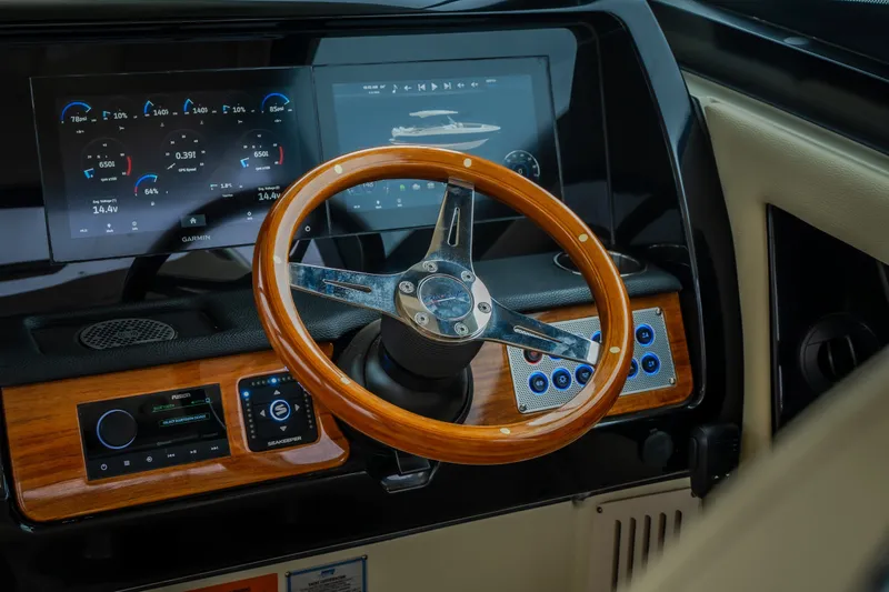 Slide: The Image of 2024 Chris-Craft Calypso 32 helm with wooden steering wheel and advanced digital display. - 34