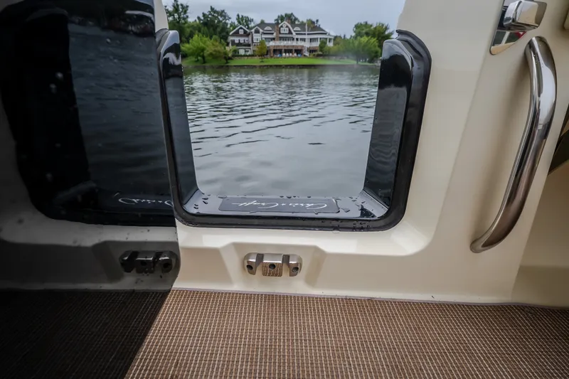 Slide: The Image of 2024 Chris-Craft Calypso 32 boat door open to scenic waterfront view. - 28
