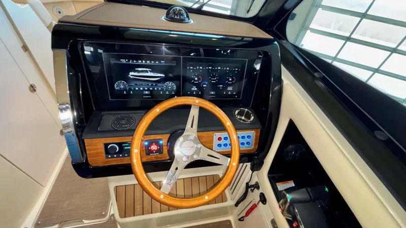 Slide: The Image of 2024 Chris-Craft Calypso 32 CT dashboard with wooden steering wheel and digital display. - 31