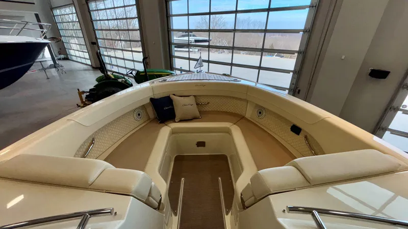 Slide: The Image of 2024 Chris-Craft Calypso 32 CT boat interior with cushioned seating in a showroom. - 38