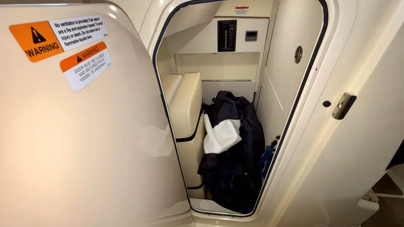 Slide: The Image of 2024 Chris-Craft Calypso 32 CT cabin storage area with safety warnings. - 39