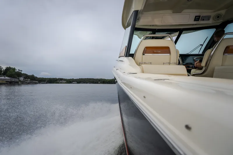 Slide: The Image of 2024 Chris-Craft Calypso 32 cruising on a serene lake under a cloudy sky. - 66