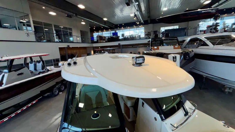 Slide: The Image of 2024 Chris-Craft Calypso 32 CT boat displayed in a showroom with other boats. - 48