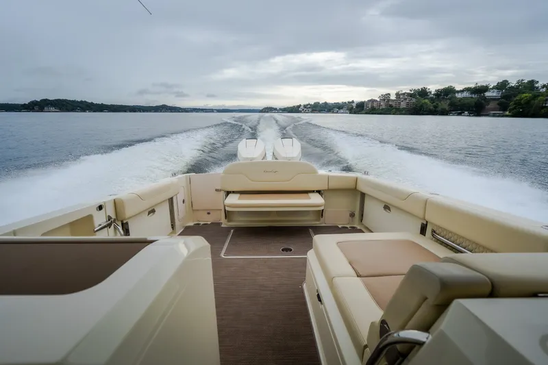 Slide: The Image of 2024 Chris-Craft Calypso 32 cruising on a scenic lake with luxurious seating. - 62