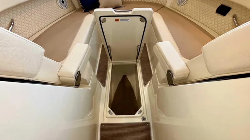 Slide: The Image of 2024 Chris-Craft Calypso 32 CT interior with beige seating and storage compartment. - 49