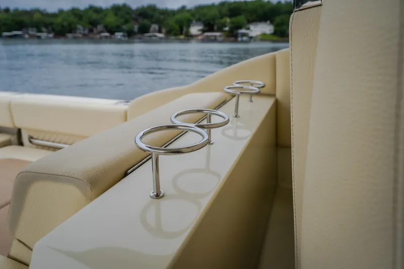 Slide: The Image of Cup holders on the 2024 Chris-Craft Calypso 32 boat, with lake view in background. - 25