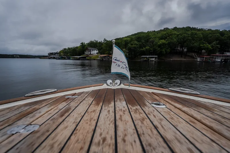 Slide: The Image of 2024 Chris-Craft Calypso 32 boat deck on a serene lake with lush shoreline. - 54