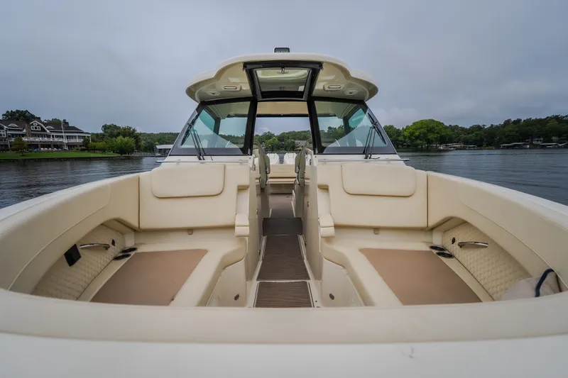 Slide: The Image of 2024 Chris-Craft Calypso 32 boat interior with beige seating on a calm lake. - 56