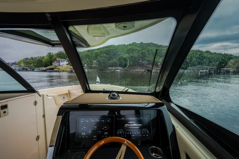 Slide: The Image of 2024 Chris-Craft Calypso 32 cockpit view with modern dashboard and scenic lake backdrop. - 43