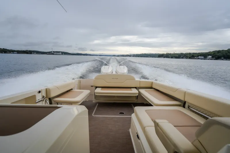 Slide: The Image of 2024 Chris-Craft Calypso 32 cruising on a lake, showcasing luxurious seating and powerful wake. - 63