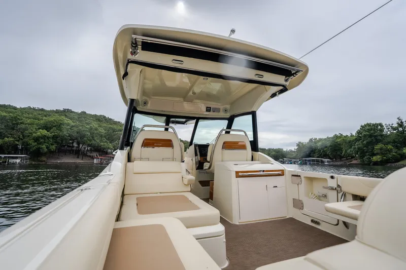 Slide: The Image of 2024 Chris-Craft Calypso 32 boat interior with seating, on a serene lake. - 22