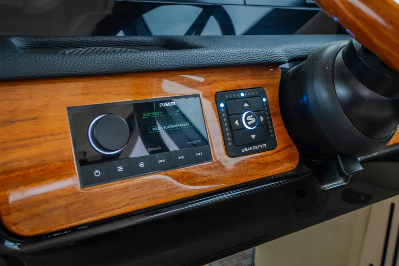 Slide: The Image of 2024 Chris-Craft Calypso 32 dashboard featuring Fusion Bluetooth audio and Seakeeper controls. - 40