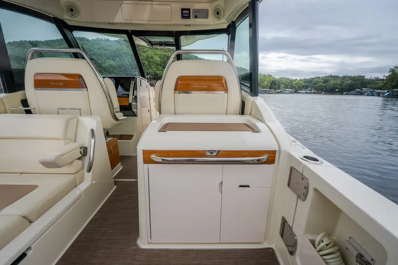 Slide: The Image of 2024 Chris-Craft Calypso 32 interior with luxurious seating and elegant design on a serene lake. - 26