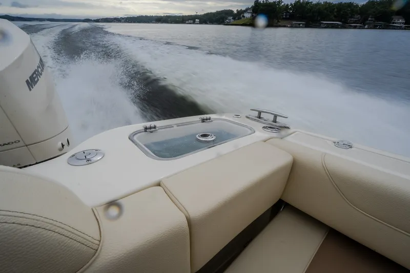 Slide: The Image of 2024 Chris-Craft Calypso 32 cruising on a lake, showcasing luxurious seating and powerful engine. - 65