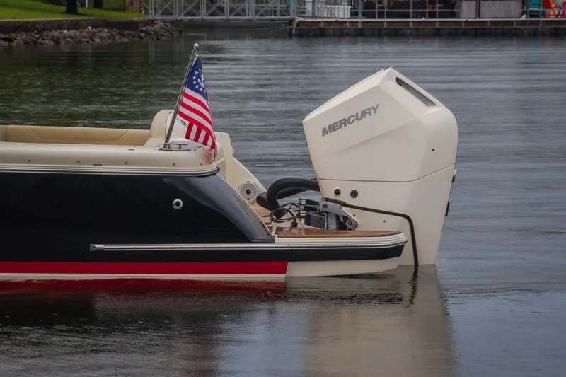 Slide: The Image of 2024 Chris-Craft Calypso 32 with Mercury engine, American flag, docked on calm water. - 16