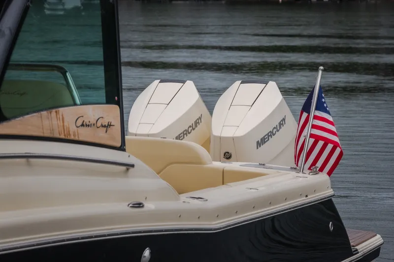 Slide: The Image of 2024 Chris-Craft Calypso 32 boat with Mercury engines and American flag on water. - 15