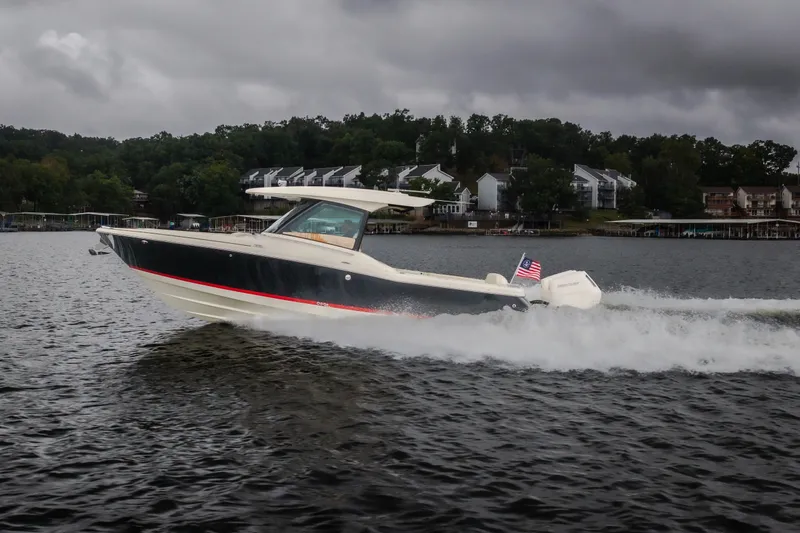 The Image of 2024 Chris-Craft Calypso 32 cruising on a lake under cloudy skies. - 2