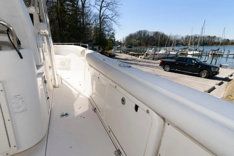 Slide: The Image of 2008 Century 2901 Center Console boat docked near a marina with parked vehicles. - 13