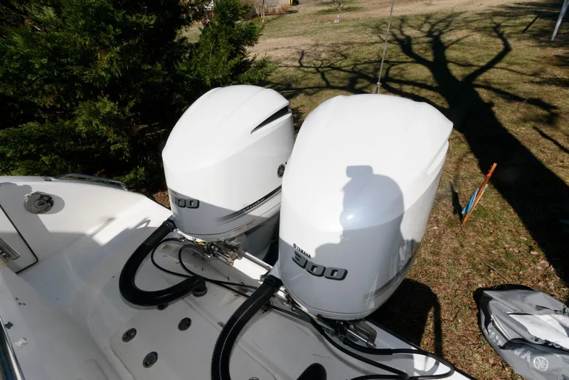 Slide: The Image of Twin outboard engines on a 2008 Century 2901 Center Console boat, parked on grass. - 16