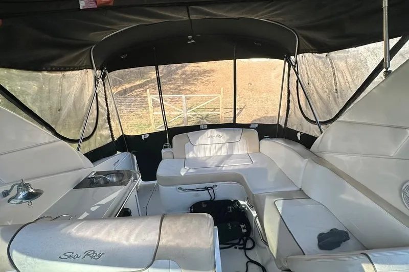 Slide: The Image of 2013 Sea Ray 280 Sundancer interior with white seating and black canopy. - 11