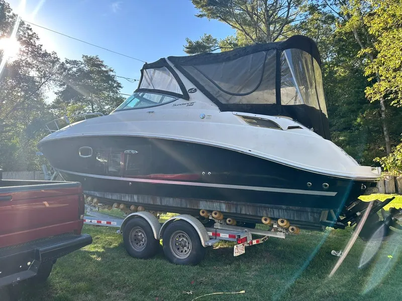 Slide: The Image of 2013 Sea Ray 280 Sundancer on trailer, parked outdoors in sunlight. - 2
