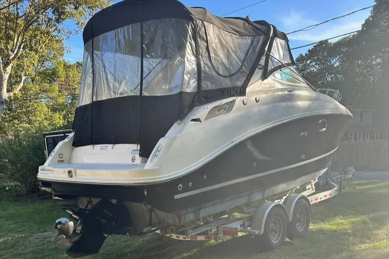 Slide: The Image of 2013 Sea Ray 280 Sundancer boat on trailer with black canopy, parked on grass. - 7