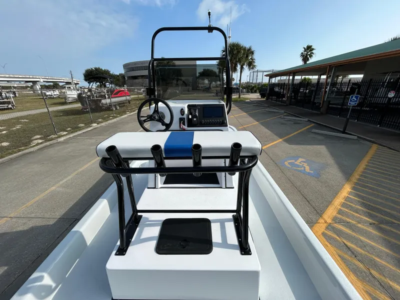 Slide: The Image of 2025 Shallow Stalker Cat 204 boat with steering console and rod holders in a marina setting. - 15