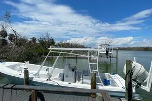 Slide: The Image of 2006 Andros Tarpon boat docked by a scenic river under a blue sky. - 3