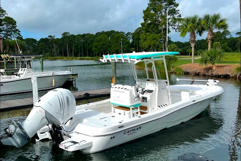Slide: The Image of 2021 Caymas 28 HB boat docked on a serene lake with lush greenery. - 1