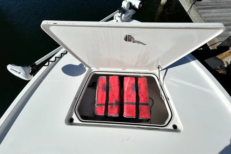 Slide: The Image of 2021 Caymas 28 HB boat storage compartment with red life jackets. - 15