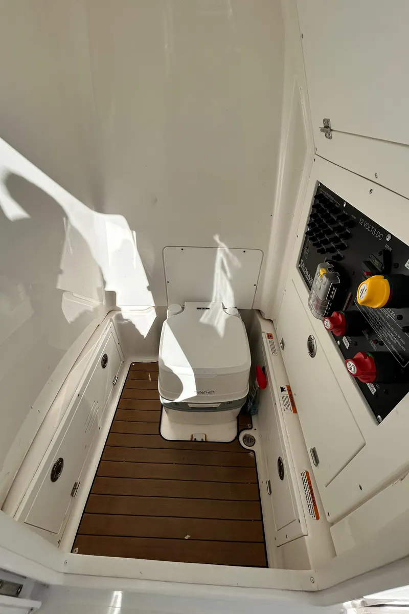 Slide: The Image of 2021 Caymas 28 HB boat interior with compact marine toilet and control panel. - 29
