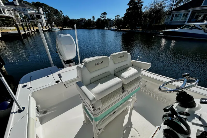 Slide: The Image of 2021 Caymas 28 HB boat interior with dual seats on a calm waterfront. - 7