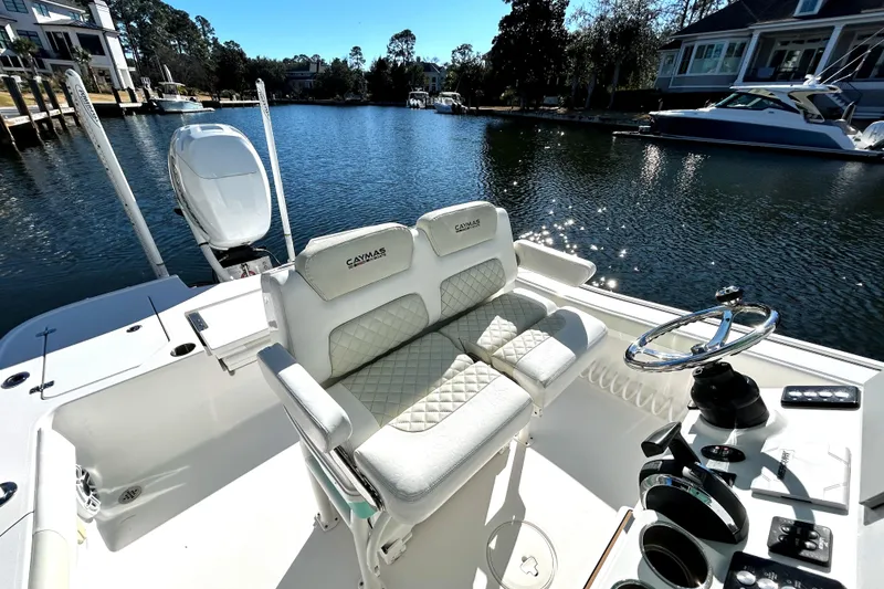 Slide: The Image of 2021 Caymas 28 HB boat interior with dual seats and steering wheel on a sunny day. - 8