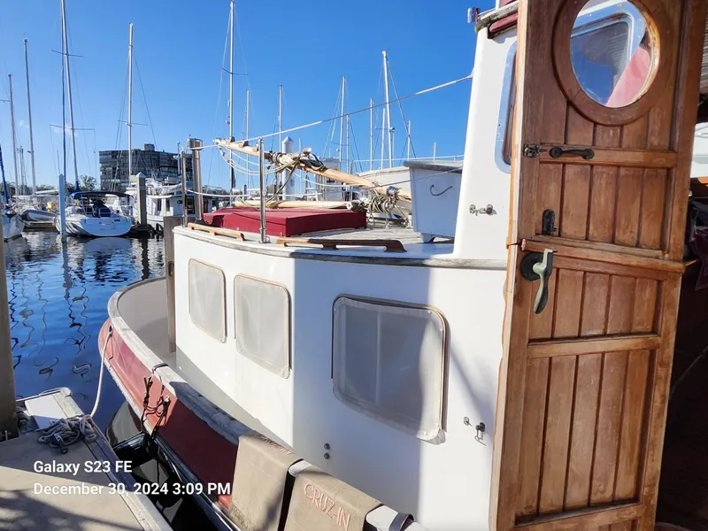 Slide: The Image of 1988 Lord Nelson Victory 37 boat docked at marina with wooden door open. - 22