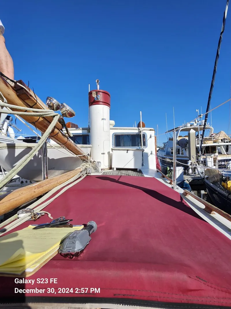 Slide: The Image of Sailboat deck view, Lord Nelson Victory 37, docked in marina under clear blue sky. - 27